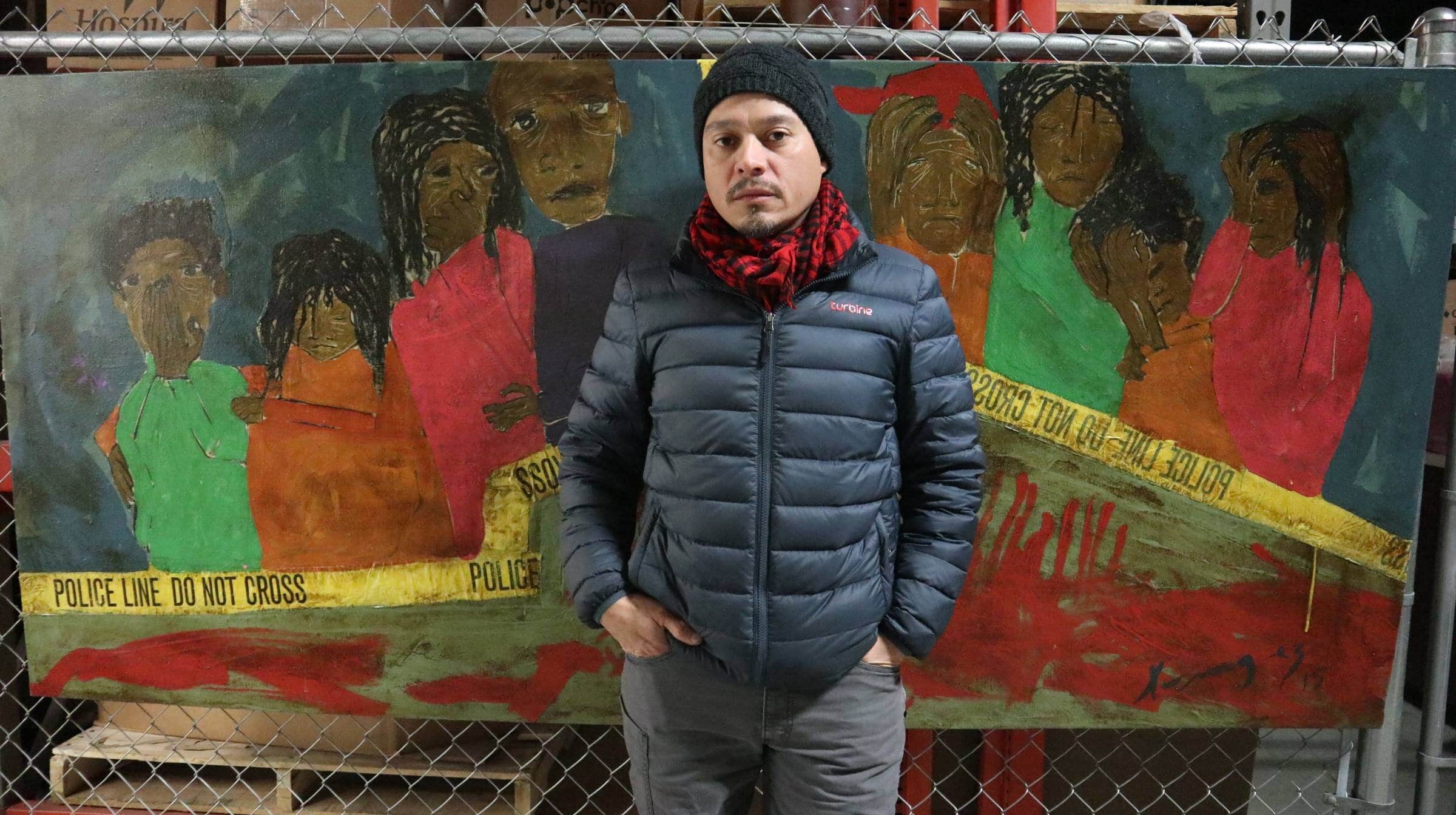 Morales in 2019 at the Centro Hispano with a painting that reflects on the violence of deportation.