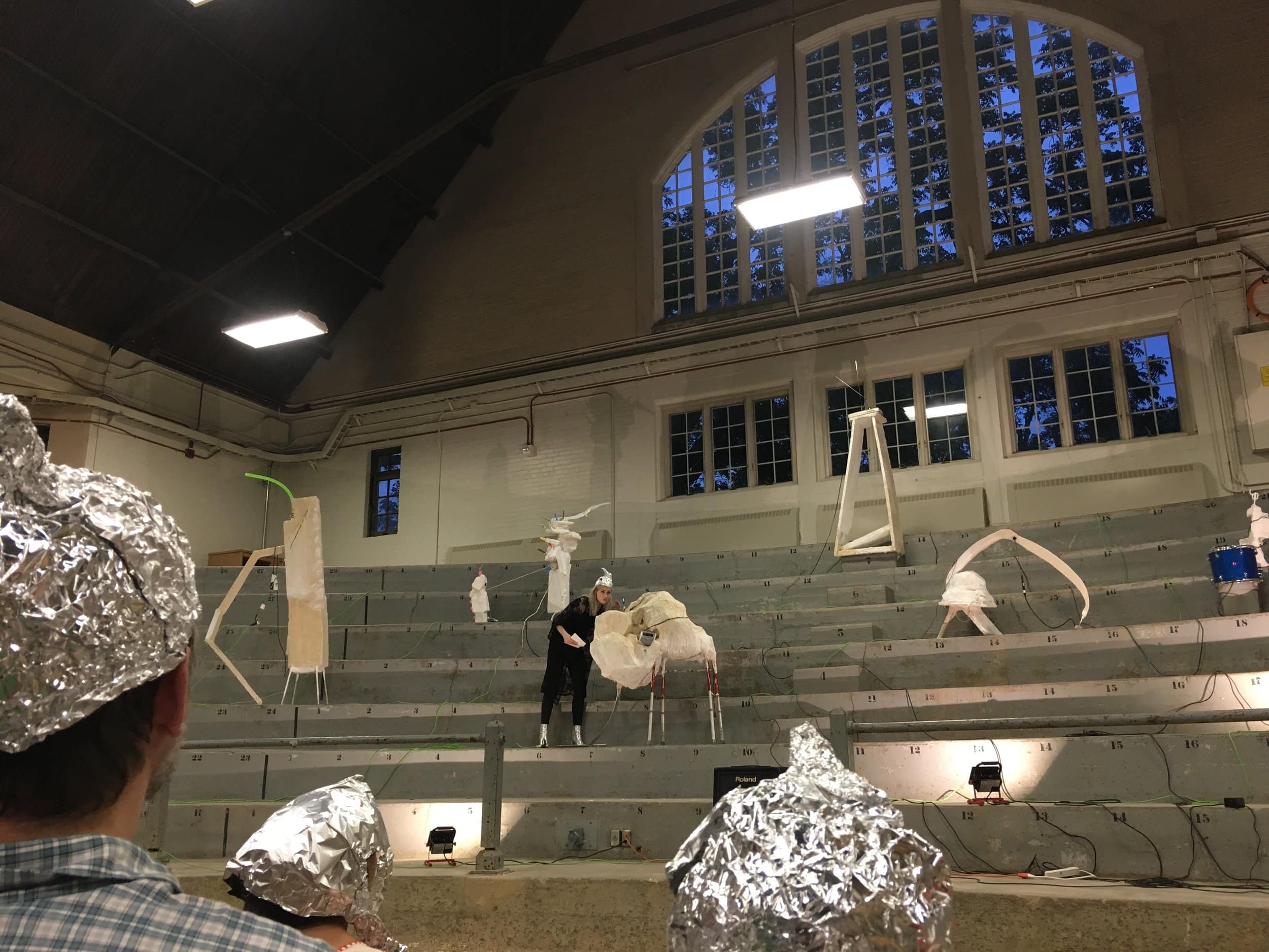 Wilson introducing the performance; hats in foreground. 