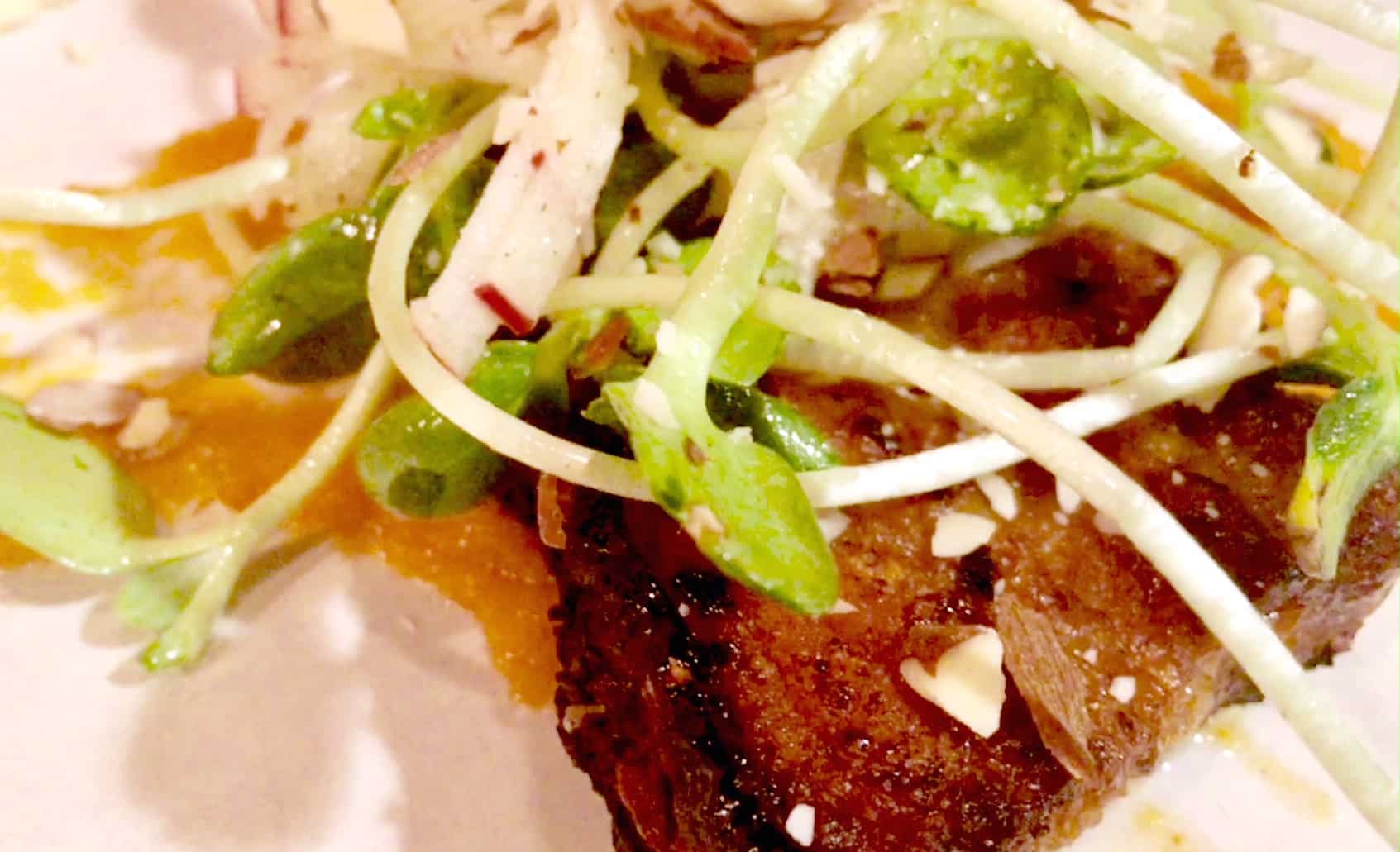 Pork bellies come spiked with sunflower shoots, almond slivers, sweet potato mash, hickory syrup, and thinly julienned apple. Photo by Adam Powell.