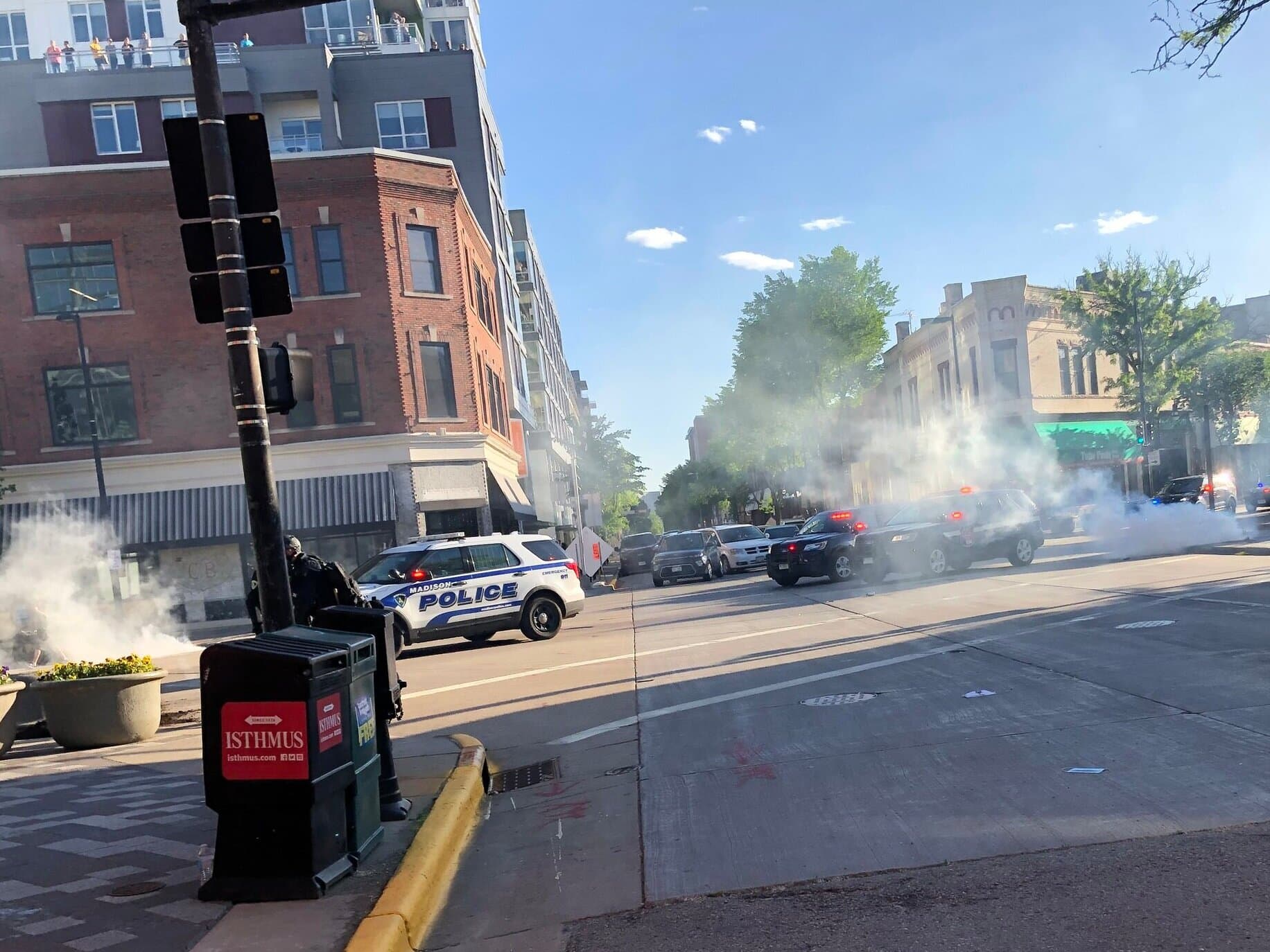 Police vehicles follow a line of riot cops down State Street toward the Capitol.