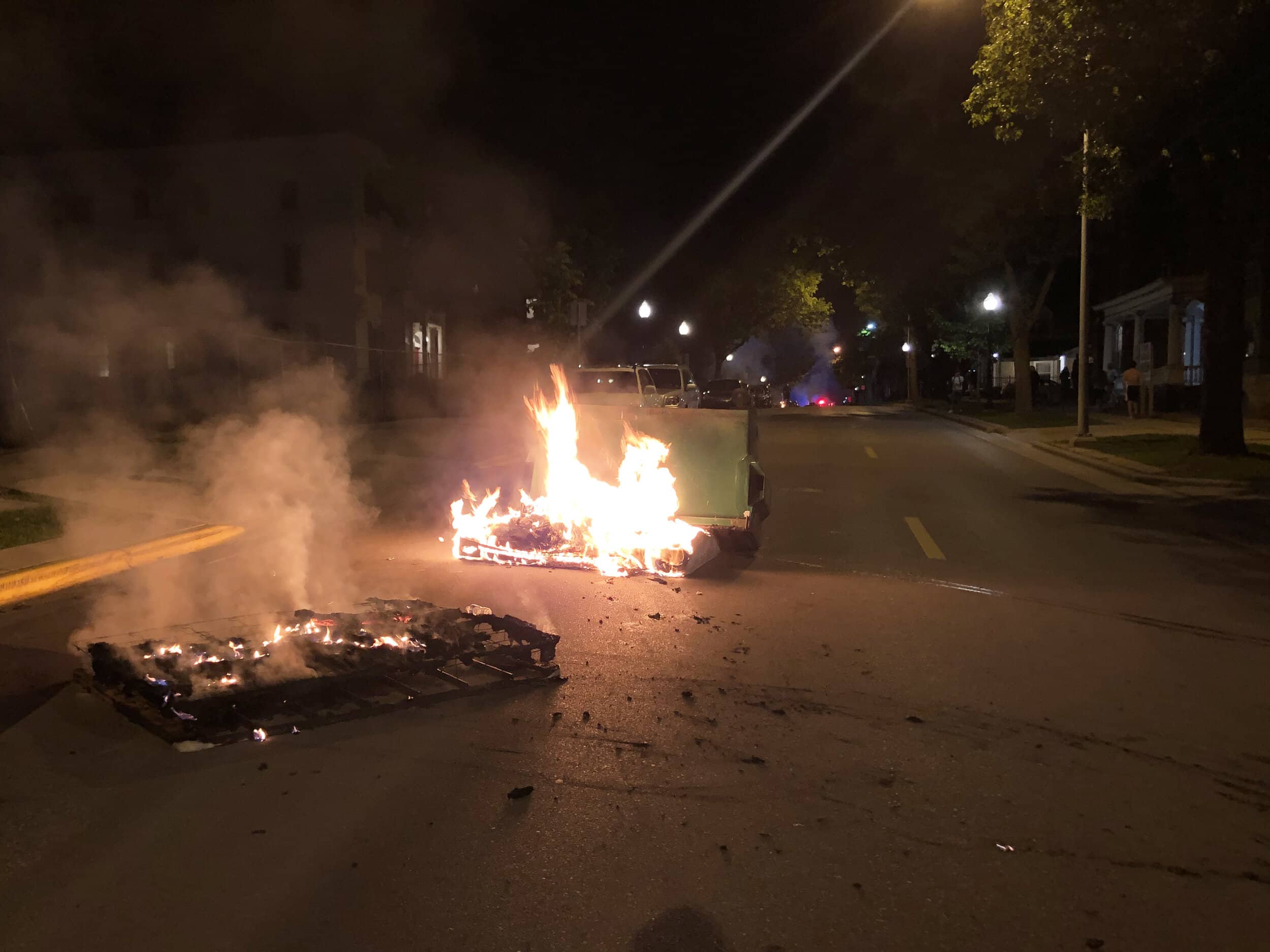 Protestors set several dumpsters on fire along Langdon Street in an effort to slow the progress of riot cops.