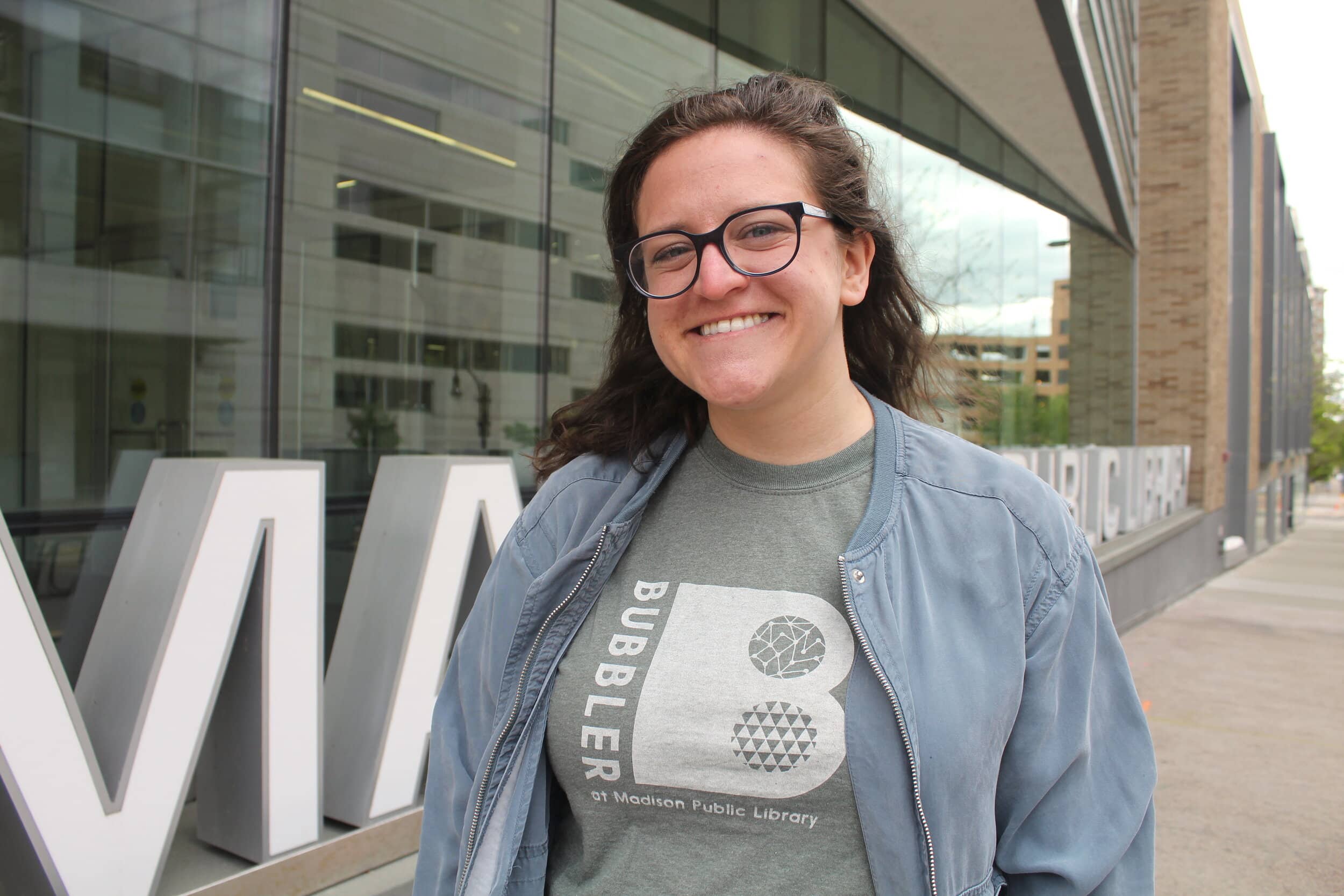 Carlee Latimer, the Madison Public Library’s Bubbler Program Assistant and one of the organizers of Print and Resist, stands in front of the Central Library in downtown Madison.