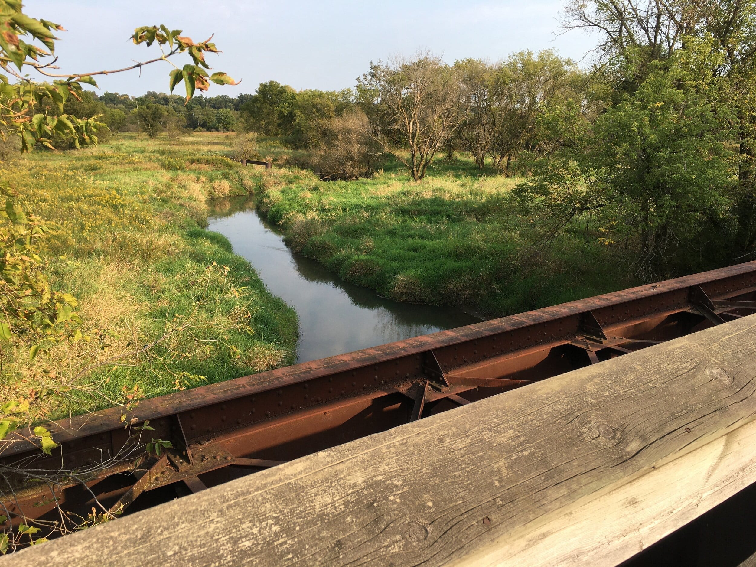 The Baraboo River meanders beneath a wooden bridge built into a railroad trestle on The 