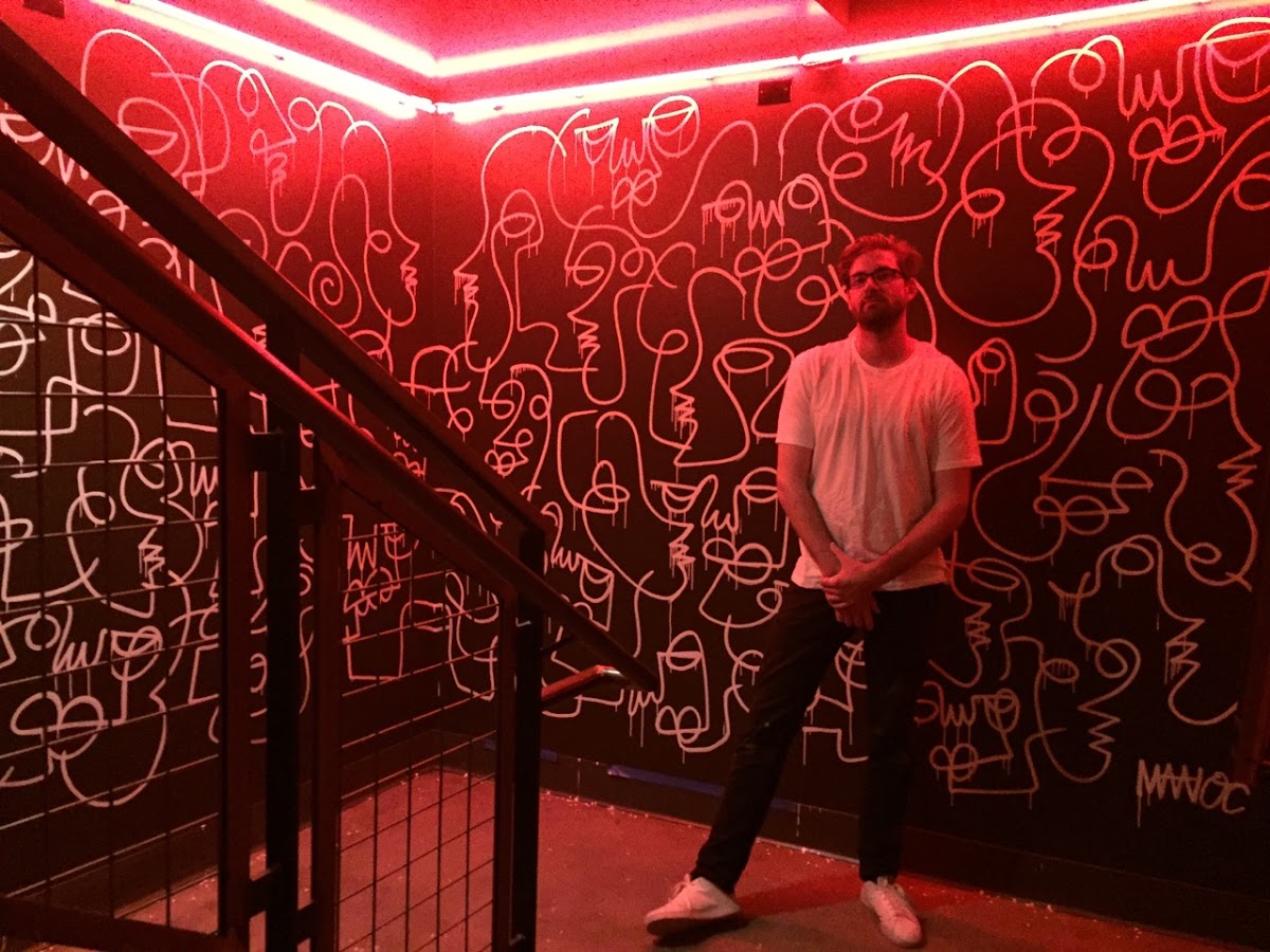 Matioc with his painting at Lucille. Photo courtesy of the artist.