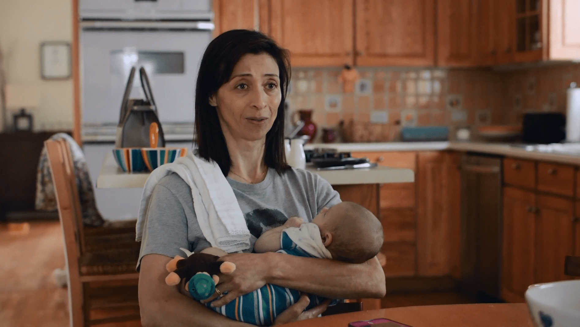 Maya (Charin Alvarez) holds newborn Wally (Ezra Gibson) in a scene from “Saint Frances.”