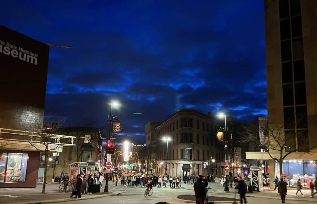 A returning crowd of protestors marches up State Street toward the Capitol Building under the streetlights. Photo by Oona Mackesey-Green.