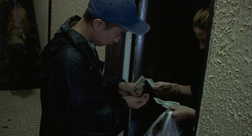 A still from the film "Take Out" shows Ming Ding (Charles Jang) collecting payment for a food delivery at a Manhattan apartment building.