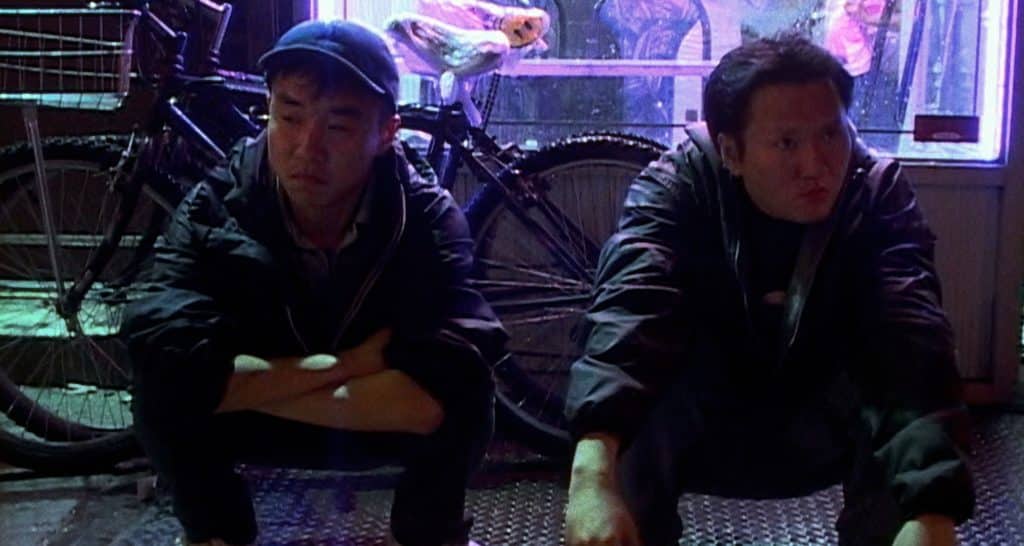 Coworkers Ming Ding (Charles Jang) and Young (Jeng-Hua Yu) kneel outside the Chinese restaurant, reflecting on their past and present outlooks.