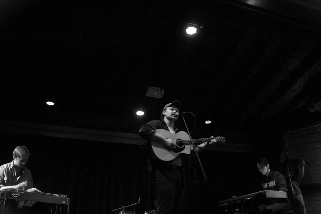A black-and-white photo of TS Foss performing as a trio at The Bur Oak. 