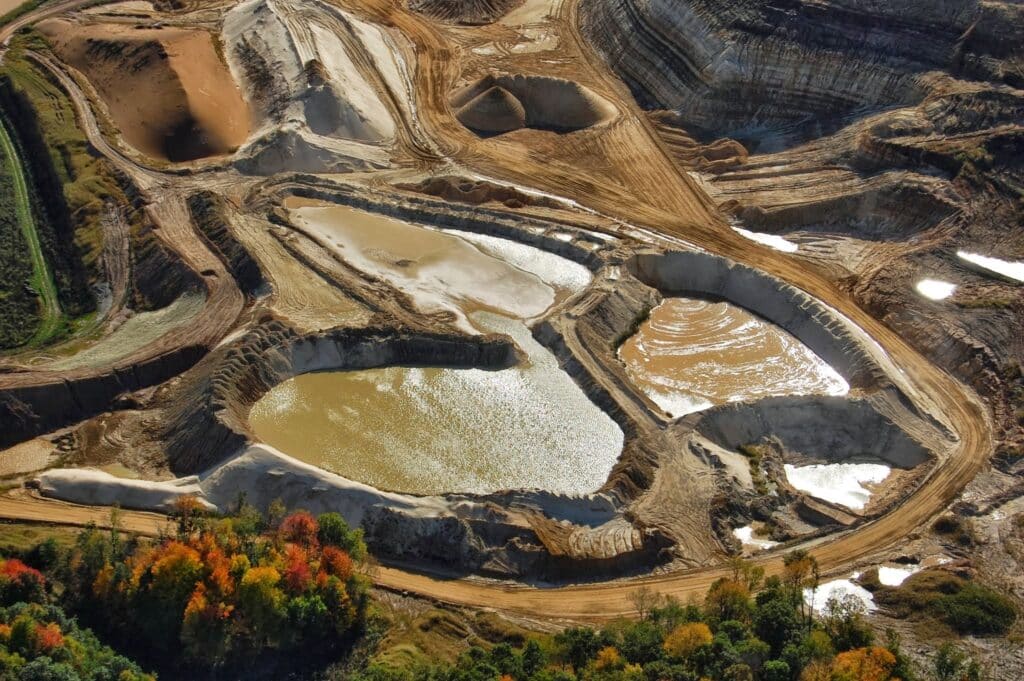 An aerial photo shows pools of greenish-brown water in a water impoundment in Auburn, Wisconsin owned by Superior Silica Sands, which is a Texas-based company.