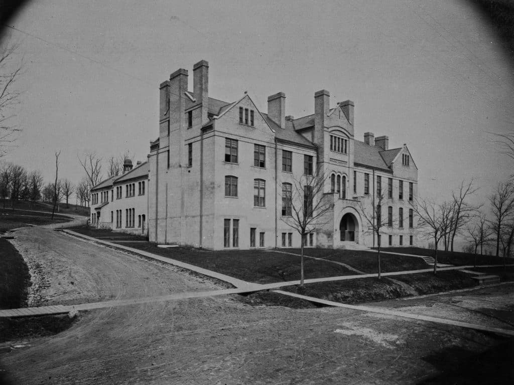 Archival photo of a brick building with many chimneys.