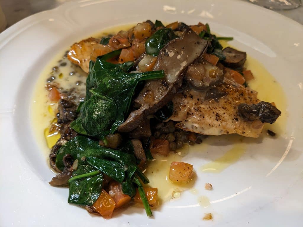 Seared Salmon entrée (bacon-braised French lentils, sautéed spinach, portobello mushrooms, tomatoes, and beurre blanc) at Sardine restaurant on Willy Street.