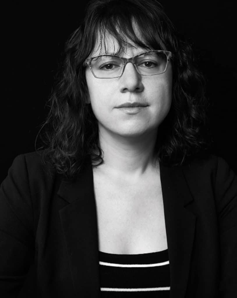 Writer-director-editor-actor Joanna Arnow poses for a black-and-white headshot with a neutral expression.