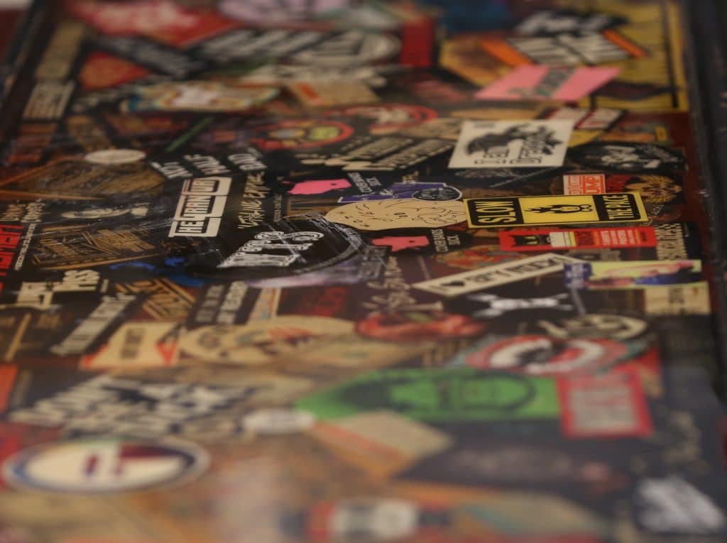 A section of a bar that was formerly part of The Frequency is shown. It's virtually coveredin a heavily overlapping collage of band stickers.