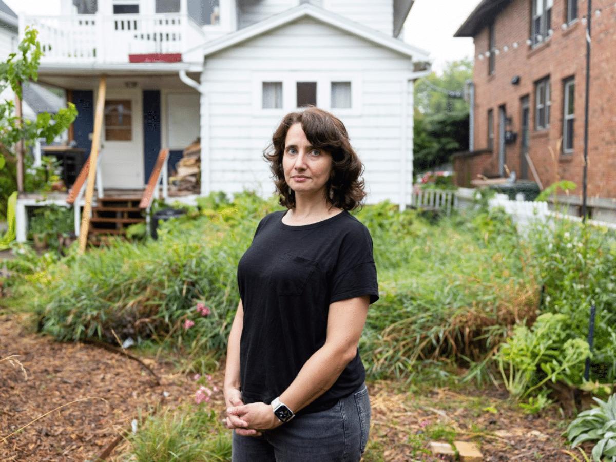 Portrait of a woman standing in her backyard.