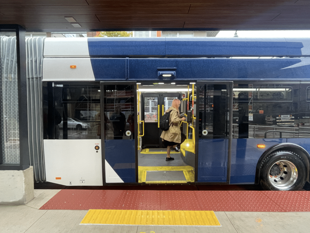A photo shows a side view of a bus boarding at a new BRT station.