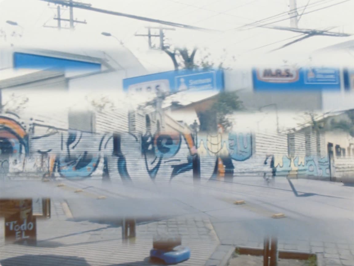 A spliced, shuffled image that consists of 12 thin horizontal strips of different shots of an urban environment. The complete image in daylight contains fragments of streets and graffitied walls.