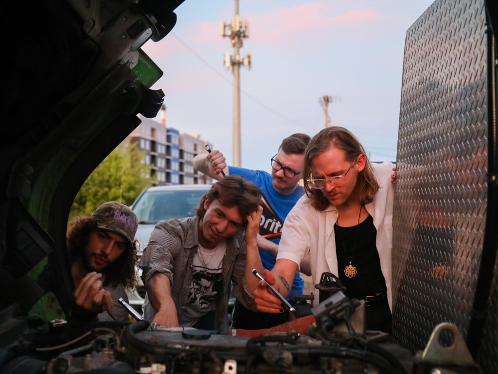 The members of Slick pretend to fix a vehicle going through a maintenance process. From Left to Right: Calvin Childress, Nate Opperman, Hance Throckmorton, and Morgen Nicodemus. 