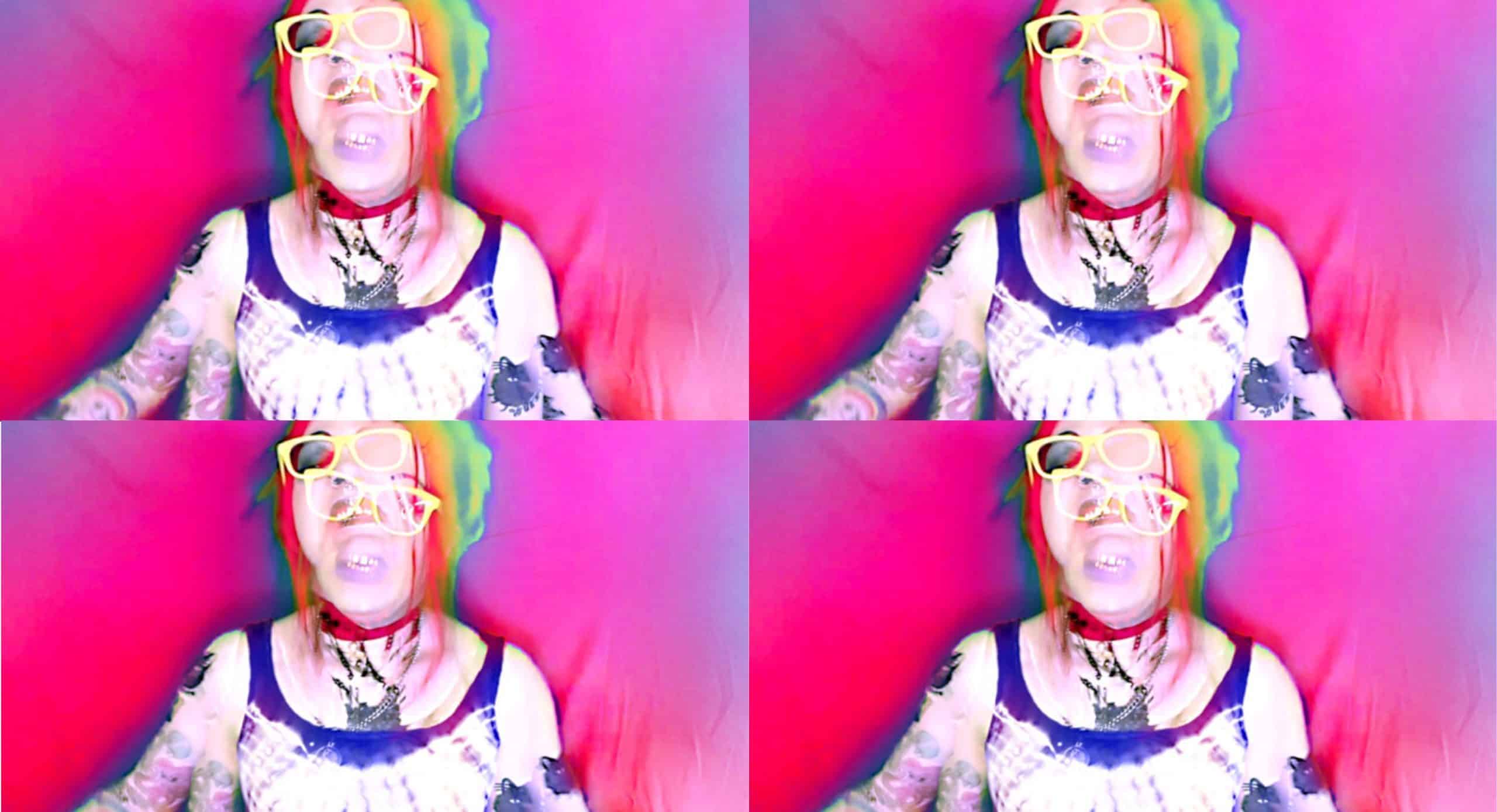 Fire-Toolz's Angel Marcloid stands in front of a soft pink-and-blue backdrop. Two images of Marcloid are stacked on top of each other, blurring her face. The image is run through a retro, color-blur filter, heightening an unnerving psychedelic effect. The image is repeated across a 2x2 grid.