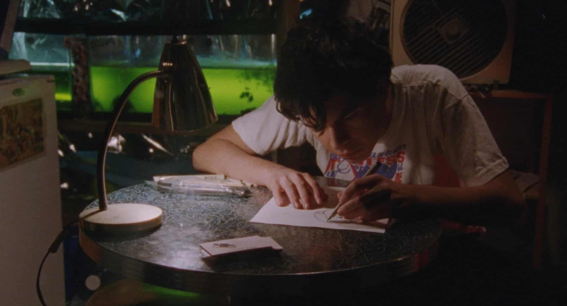 Robert (Daniel Zolghadri) diligently works on his comic in the dimly lit basement of his Trenton apartment.