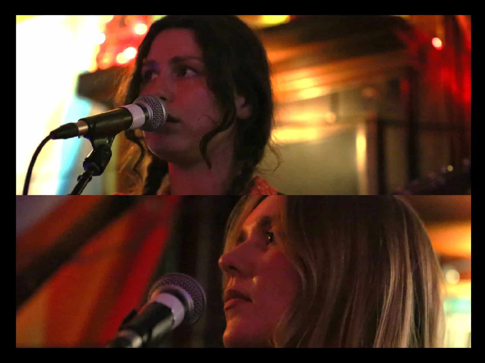A thin black border surrounds two photos that each take up roughly half the image, running horizontally. The top image is Emma O'Shea in close-up, singing into a microphone and looking out at the audience. The bottom image is Kate Ruland in close-up, eyes closed, preparing to sing into the mic. Both photos were taken at the band's performance at Mickey's Tavern in mid-May.